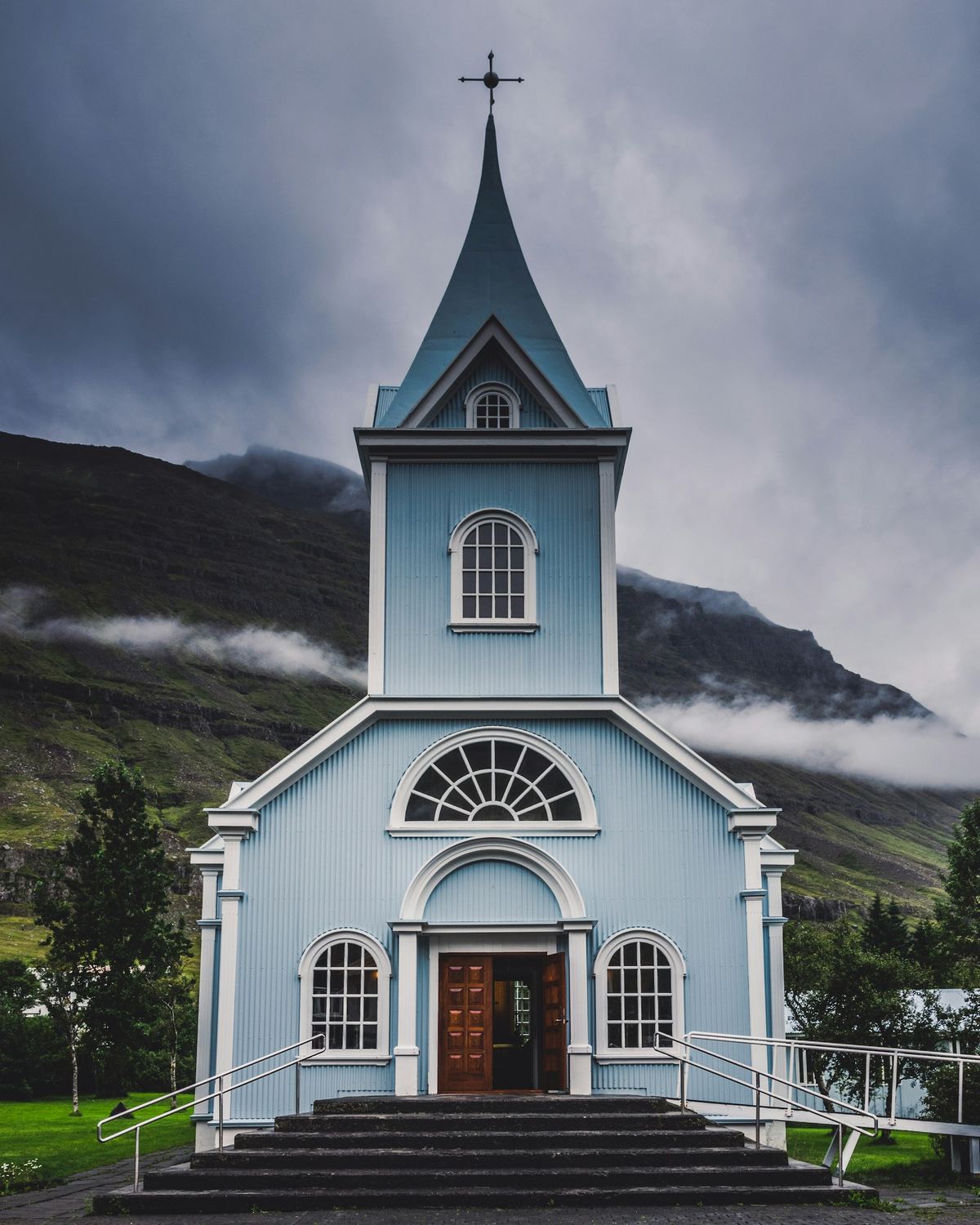 A welcoming country church with a steeple and open doors